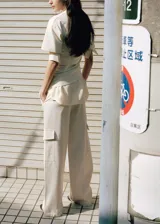 Pantalón recto color blanco crudo, de tiro medio con bolsillos laterales y bolsillos cargo con solapa en las piernas.