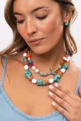 Collar corto compuesto por cuentas grandes de piedra turquesa irregular, alternadas con cuentas circulares blancas, naranjas y lilas.