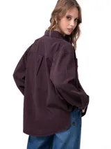 Camisa oversize de pana color bordó, de manga larga con puños abotonados, cierre frontal de botones y bolsillos dobles en el pecho.