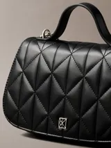 Cartera acolchada Calvin Klein de mano, color negro, con diseño matelassé en rombos, asa superior y correa de cadena metálica. Incluye pequeño logo metálico en la parte frontal.