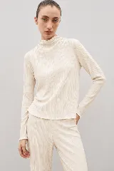 Top de manga larga con textura plisada, cuello alto y terminaciones con ondas en puños y ruedo.