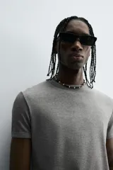 Camiseta gris de corte slim fit, confeccionada en tejido de algodón con elasticidad, cuello redondo y manga corta.