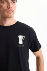 Remera negra de manga corta, confeccionada en algodón, con estampa en la espalda que presenta el texto "The Coffee Roasters Club" y el diseño de una cafetera moka.