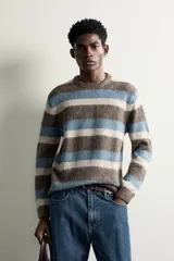 Sweater de punto con textura efecto pelo, cuello redondo, manga larga y diseño a rayas horizontales en tonos marrón, celeste y beige.