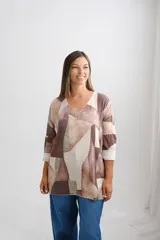 Sweter de corte amplio con escote en V y mangas largas. Presenta un diseño geométrico estampado en tonos tierra, beige y tostado.