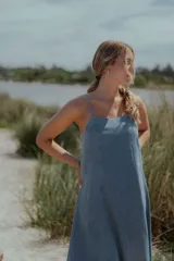 Vestido midi de denim color celeste, con escote recto, breteles finos y corte evasé amplio.