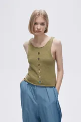 Musculosa verde melange de tejido de punto con tres aberturas circulares en el frente.