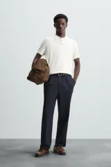 Polo de punto negro, manga corta, con cuello solapa y cierre frontal de tres botones. Presenta un calce regular y acabados en rib en mangas y ruedo.