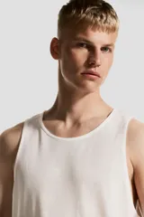 Musculosa deportiva blanca, de corte estándar y cuello redondo, confeccionada en tejido funcional DryMove™ que absorbe el sudor.