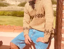 Sweater tostado de lana con cuello en V y diseño de copos de nieve en marrón.