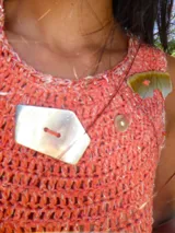 Vestido largo de crochet en color azul marino, con diseño sin mangas y cuello redondo. Presenta un detalle de apliques metálicos en la zona del pecho y un ruedo con volado de textura contrastante.