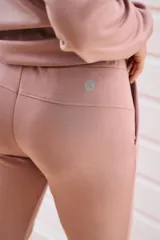 Pantalón babucha deportivo color lila, con elástico en la cintura y puños, cordones regulables y dos bolsillos laterales.