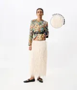 Pollera midi recta de color crudo, con textura de flecos y pelo sintético, corte por debajo de la rodilla y forro interior.