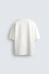 Camiseta de corte relajado confeccionada en algodón compacto, con cuello redondo y mangas cortas sin costura de sisa.