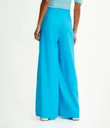 Pantalón modelo pantalona de corte amplio, confeccionado en una mezcla de viscosa y lino. Presenta cintura con botón, cierre de cremallera y bolsillos laterales.