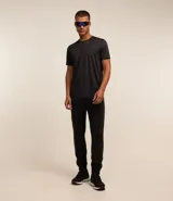 Pantalón deportivo de corte ajustado, color negro, con cintura elástica, cordón de ajuste, bolsillos laterales con cremallera, bandas laterales en contraste y cremalleras en los tobillos.