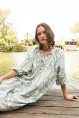 Vestido camisero con estampado floral en tonos celeste y blanco, cuello a la base, manga al codo y botones al frente.