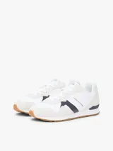 Championes de diseño runner de Tommy Hilfiger, confeccionados en una combinación de textil y cuero en color blanco, con detalles en gris claro, azul marino y suela de goma color caramelo.