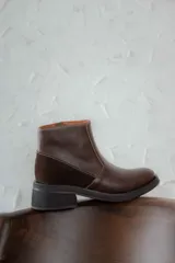 Bota corta de cuero marrón con panel trasero de gamuza en tono más oscuro, suela de goma negra y taco cuadrado bajo.