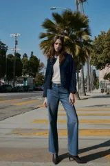 Jeans de tiro alto con diseño de cinco bolsillos, pernera recta y corte largo. Presenta cierre frontal con cremallera y botón metálico.