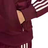Campera deportiva adidas modelo Firebird, color bordó con las icónicas tres tiras blancas en las mangas y logo del trébol bordado en el pecho. Cuenta con cuello alto, cierre frontal completo y puños acanalados.