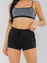Set de top negro con brillos y tirantes regulables, combinado con short negro de cintura elástica con cordón de ajuste.