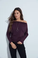 Top de manga larga con escote bote amplio, diseñado para usar ligeramente caído sobre los hombros. Presenta una silueta entallada y tejido liso, liviano y adaptable al cuerpo.