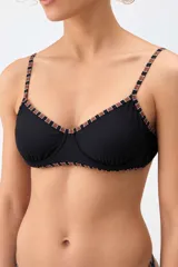 Top de bikini estilo corsetero color negro con detalles estampados a cuadros en los bordes y breteles.