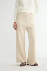 Pantalón de punto de corte ancho y tiro alto, con cintura elástica y bolsillos frontales tipo parche. Presenta un diseño minimalista con terminaciones al corte en el ruedo.