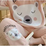 Conjunto de pijama de dos piezas confeccionado en tela de plush suave y abrigada. Incluye una remera de manga larga con diseño estampado de Totoro y pantalón largo a juego con puños en contraste.