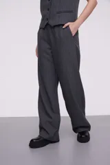 Pantalón de vestir gris oscuro con finas rayas verticales blancas, corte palazzo y bolsillos laterales.