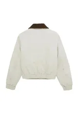 Campera acolchada corta color beige, con cuello de pana en contraste color marrón. Cuenta con cierre frontal de cremallera y botones a presión, bolsillos laterales, y puños y bajo elásticos.