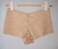 Short de tiro medio confeccionado en puntilla elastizada color beige claro, con diseño floral y fundillo de algodón 100%.