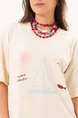 Remerón oversize de algodón color manteca, con mangas cortas y estampa exclusiva temática marina en el frente.