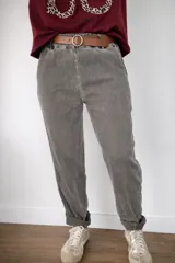 Pantalón de corte holgado con textura suave tipo gamuza, cintura elástica y cinto incluido. Presenta un diseño relajado con costuras verticales frontales y ruedo doblado.