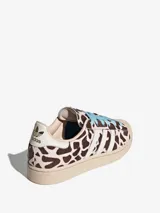 Championes Adidas Superstar II con diseño de estampado animal print tipo vaca, puntera de goma clásica, tres tiras laterales blancas y cordones en color celeste.