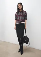 Sweater de punto con diseño de rombos estilo argyle en tonos bordó, gris y blanco, con cuello redondo y manga larga.