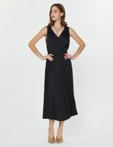 Conjunto compuesto por un buzo de tejido calado con cuello redondo y mangas largas, y un vestido midi de satén con falda plisada. Ambas piezas son de color negro y pueden combinarse o utilizarse por separado.