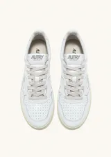 Championes de cuero blanco con diseño inspirado en el tenis de los años 80. Presenta puntera perforada, lengüeta con etiqueta de la marca, cuello acolchado y suela de goma en tono crema con logo grabado en el lateral.