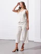 Pantalón crop de corte recto y estilo casual, confeccionado en una mezcla de fibras naturales y sintéticas. Presenta pretina trasera elastizada con lazo de ajuste frontal y bolsillos laterales verticales.
