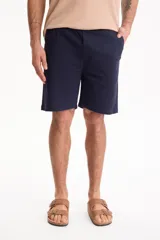 Bermuda de gabardina con spandex, cintura elastizada y cordón ajustable, de corte recto y color azul marino.