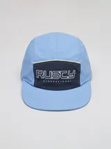 Gorra tipo five-panel de nylon color celeste, con panel frontal en contraste color azul marino y logo de la marca bordado en blanco. Presenta una costura decorativa en color amarillo sobre el panel frontal.