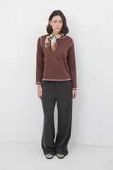 Pantalon de corte sastrero y pierna ancha, confeccionado en tela melange. Presenta cintura con trabillas, cierre frontal con botón y bolsillos laterales.