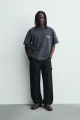 Remera de algodón con efecto lavado, corte relajado, cuello redondo y manga corta. Presenta un gráfico estampado en el pecho con la inscripción Posty Co.