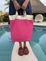 Bolso tote grande de fieltro color fucsia con detalles en cuero dorado y doble asa de mano.