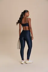 Calza deportiva de tiro alto con diseño de alta compresión y textura acanalada con leve brillo. Cuenta con un bolsillo trasero en la cintura y tecnología de ajuste adaptable.