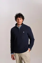 Sweater de punto acanalado color azul marino, con cuello alto y cierre frontal parcial. Presenta el logo de la marca bordado en el pecho y puños con terminación elástica.