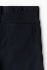 Pantalón de sarga de algodón con corte slim fit, cierre de cremallera y botón, diseño clásico de cinco bolsillos.