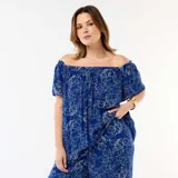 Blusa azul de crepé con estampado floral blanco, diseño fluido con escote off-shoulder y mangas cortas abullonadas.