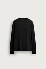 Camiseta relaxed fit de manga larga y cuello redondo, confeccionada en tejido de algodón con estructura waffle en color negro.
